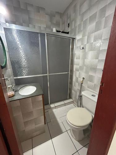 a bathroom with a shower and a toilet and a sink at Recanto dos Passáros in Prado