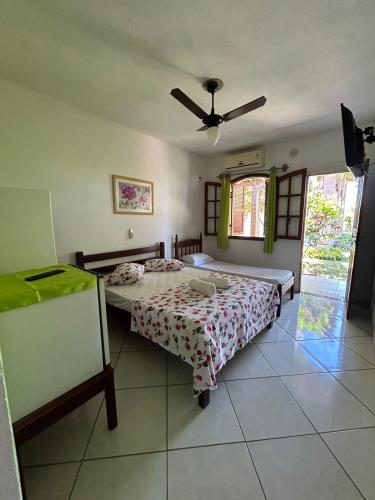a bedroom with two beds and a ceiling fan at Recanto dos Passáros in Prado