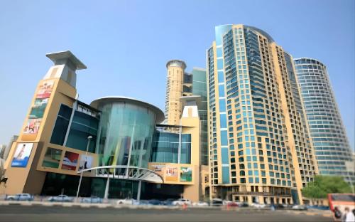a large building with tall buildings in the background at Corniche Street - New Suave Room in Abu Dhabi