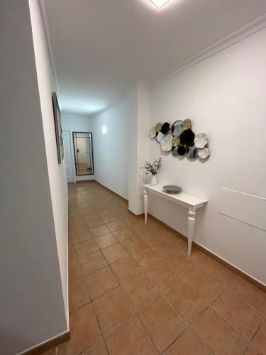 a hallway with a table and pans on the wall at APARTAMENTOS JUAN RAMÓN JIMÉNEZ 3 in Utrera