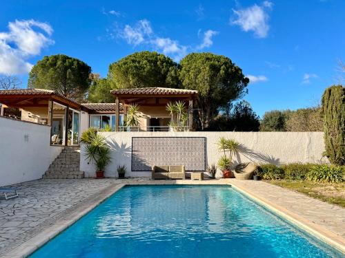 a swimming pool in front of a house at Au Bonheur Dezange in Pézenas