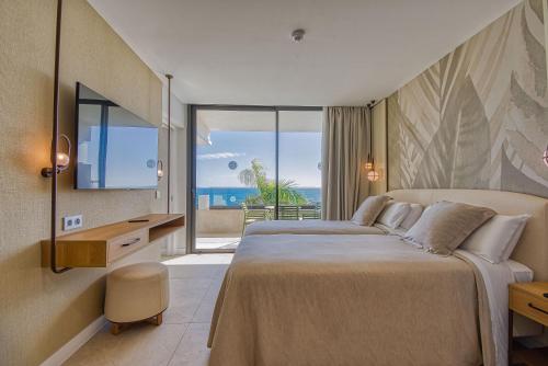 a bedroom with a bed with a view of the ocean at RELAXIA BEVERLY SUITES in Playa del Ingles