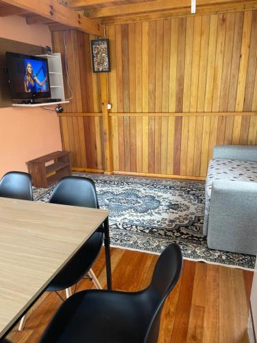 Habitación con mesa, sillas y TV. en Pousada Boa Vista, en Urubici