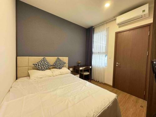um quarto com uma grande cama branca e 2 almofadas em Happy House em Ha Long