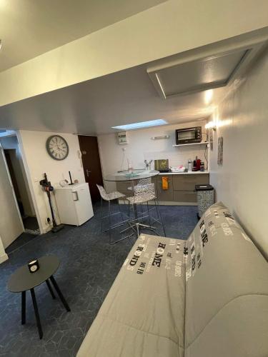un salon avec un canapé et une cuisine dans l'établissement Joli petit F1 plein centre ville, à Eu