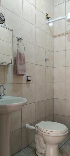 y baño con aseo y lavamanos. en kitnet Marilia 2, en Marília