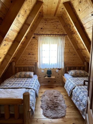 Schlafzimmer im Dachgeschoss mit 2 Betten und einem Fenster in der Unterkunft Vila Durmitorska bajka in Žabljak