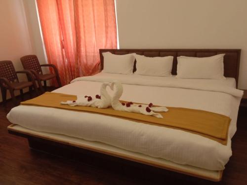 a bedroom with a bed with two towel animals on it at Tulip in green meadows in Yercaud