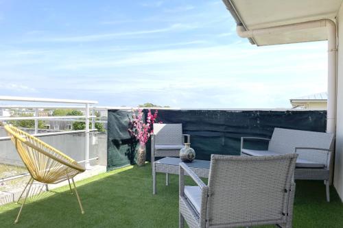 a patio with chairs and a table on a balcony at Le Rooftop - Terrasse - Parking - Piscine in Caen