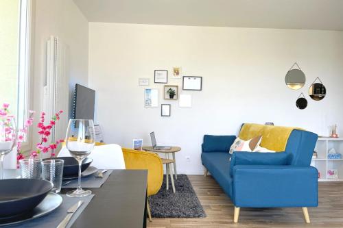 a living room with a blue couch and a table at Le Rooftop - Terrasse - Parking - Piscine in Caen