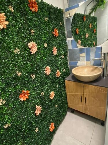 ein Badezimmer mit einer grünen Wand mit Blumen in der Unterkunft Studio cosy avec piscine in Martigues
