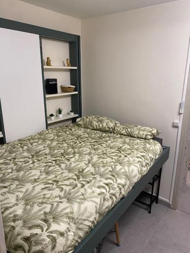 ein Schlafzimmer mit einem Bett in einem Zimmer in der Unterkunft Studio cosy avec piscine in Martigues