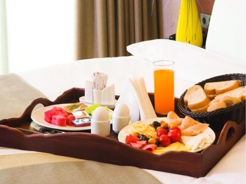 イスタンブールにあるブルーウェイ ホテル ヒストリカルのベッドの上にフルーツとパンのトレイ