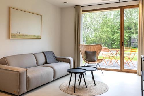 sala de estar con sofá, mesa y sillas en Vakantiewoning Duisbeke Logies en Oudenaarde