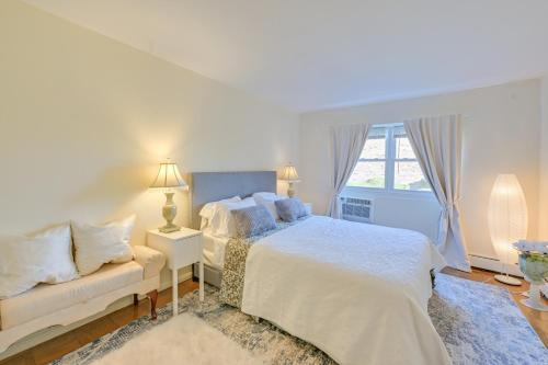 a white bedroom with a bed and a couch at Cozy Bay Shore Condo Near Museums and Outdoor Rec! in Bay Shore