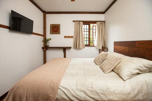 - une chambre avec un grand lit et une télévision dans l'établissement RUSTIKA Bed and breakfast, à Viña del Mar