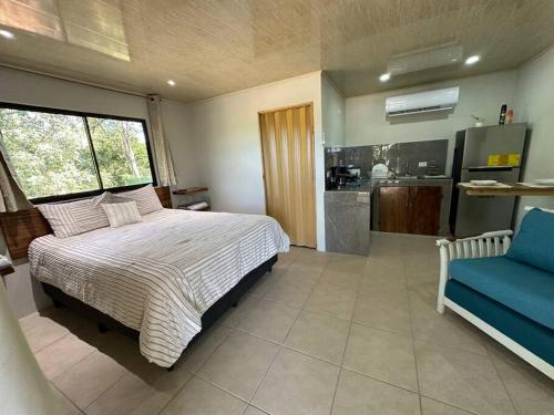 1 dormitorio con 1 cama grande y 1 silla azul en Apartamento Villa, en Villarreal