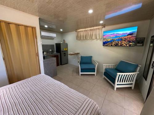 a bedroom with a bed and two chairs and a kitchen at Apartamento Villa in Villarreal