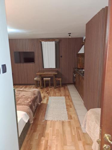 1 dormitorio con 2 camas y mesa. en Rooms and apartmants Mirovic, en Kolašin