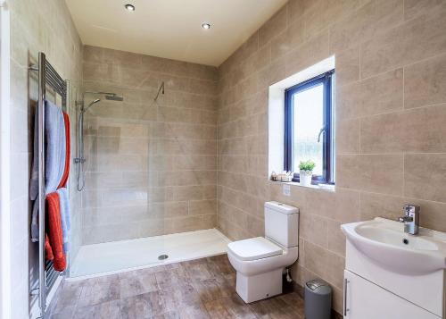 a bathroom with a toilet and a shower and a sink at Beech Tree Lakes Lodges in Hatfield