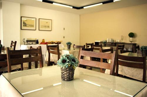 een eetkamer met een tafel met een potplant erop bij Hotel Gaivota in Recife