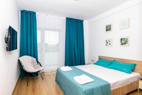 a bedroom with a bed with blue sheets and a window at Apartament Central in Craiova