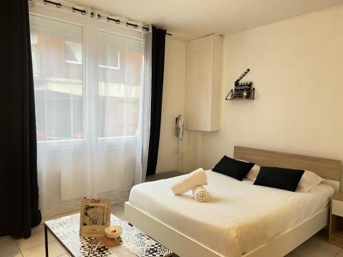 une chambre avec un lit blanc et une fenêtre dans l'établissement Le Worker 1, à Calais