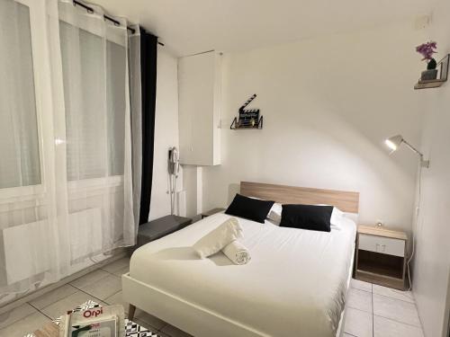 une chambre avec un grand lit blanc et une fenêtre dans l'établissement Le Worker 1, à Calais