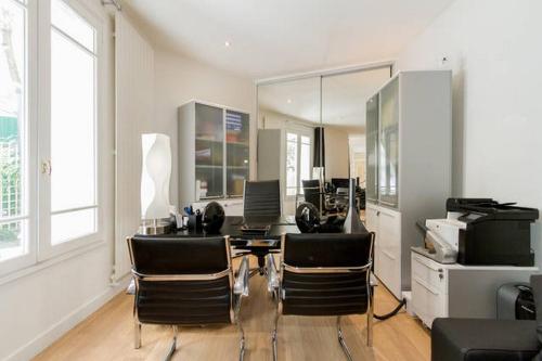un salon avec une table et des chaises de salle à manger dans l'établissement Luxury Flat with patio garden, à Paris