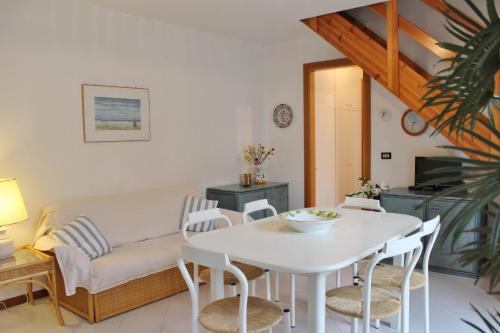 ein Wohnzimmer mit einem weißen Tisch und einem Sofa in der Unterkunft Appartamenti Rosanna in Grado
