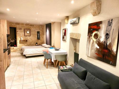 - un salon avec un canapé et un lit dans une chambre dans l'établissement La Venelle, à Sarlat-la-Canéda