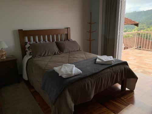 a bedroom with a bed with two towels on it at Cantinho nascer do sol in Campos do Jordão