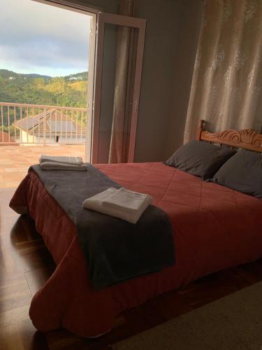 a bed in a bedroom with a large window at Cantinho nascer do sol in Campos do Jordão