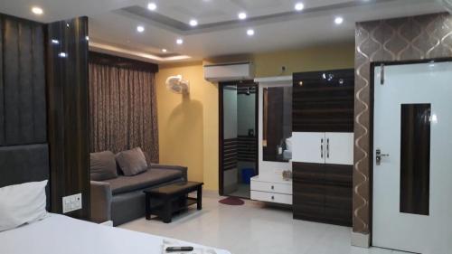 Hotel Deep Chinarpark,Near kolkata airport في Salua: غرفة نوم بسرير واريكة ومرآة