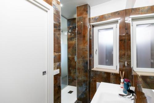 a bathroom with a sink and a glass shower at Luxury 144 B&B in Crotone