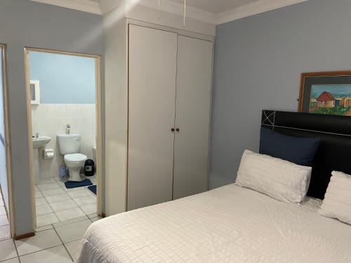 a bedroom with a bed and a bathroom with a toilet at Pendleberry Grove Unit 51 in Bela-Bela