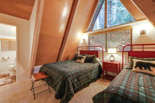 1 dormitorio en el ático con 2 camas y ventana en Pet-Friendly Arnold Cabin with Deck and EV Charger!, en Arnold