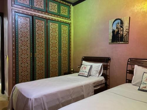 - 2 lits dans une chambre aux murs verts dans l'établissement Maison d'Hôtes Akchour, à Chefchaouen