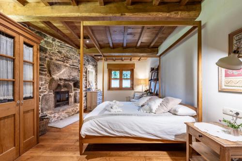 ein Schlafzimmer mit einem Bett und einem Kamin in der Unterkunft Fee4Me La Casita de Oza in A Coruña