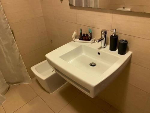 a bathroom with a white sink and a toilet at Kennedy Apartment in Quattromiglia