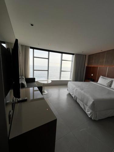 um quarto com uma cama e uma secretária com uma televisão em Hotel Nacional no Rio de Janeiro
