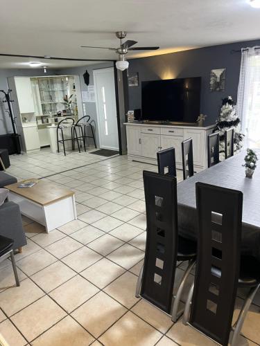une salle à manger et un salon avec une table et des chaises dans l'établissement Gîte du Domaine de La Reine Blanche, à Criquetot-sur-Longueville