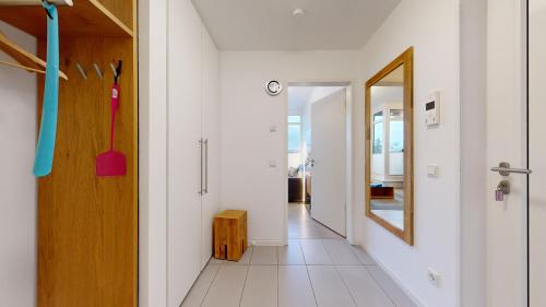 a hallway with white walls and a wooden door at DünenResort in Binz, strandnahe und moderne FeWos mit Balkon, teilweise mit Meerblick, in Binz