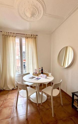 uma sala de jantar com uma mesa, cadeiras e um espelho em Cozy Ploblesec Apartment em Barcelona