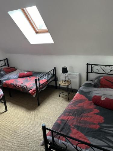 1 dormitorio en el ático con 2 camas y tragaluz en Gîte du Domaine de La Reine Blanche, en Criquetot-sur-Longueville
