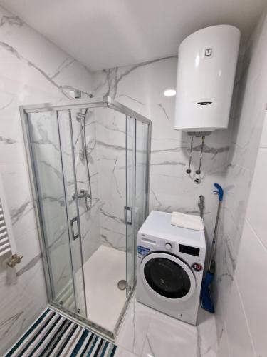 La salle de bains est pourvue d'une douche et d'un lave-linge. dans l'établissement Apartment 4th. Floor II, à Banja Luka