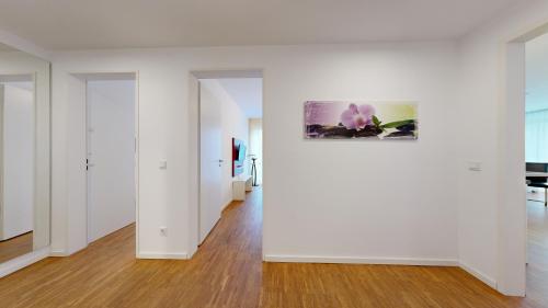 an empty room with white walls and wood floors at DünenResort in Binz, strandnahe und moderne FeWos mit Balkon, teilweise mit Meerblick, in Binz