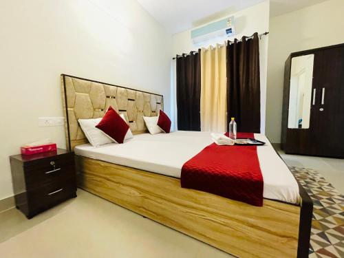 a bedroom with a large bed with a red blanket at ATULYAM HARSHADA STAYS LUCKNOW in Goshainganj