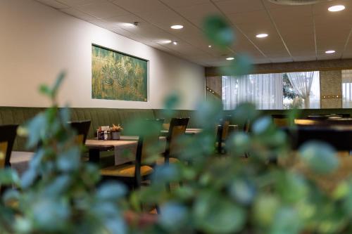 a restaurant with tables and chairs and a painting on the wall at Art Hotel superior in Zalakaros