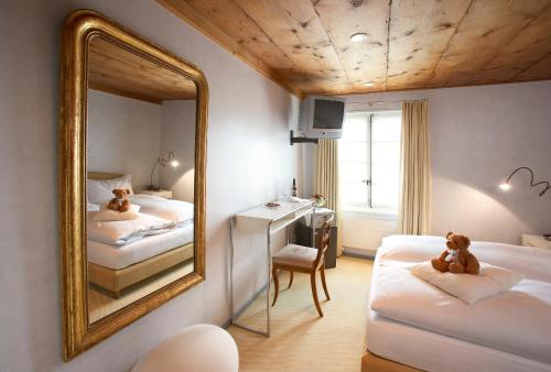 a room with two beds and a mirror at Romantik Hotel de L'Ours in Sugiez